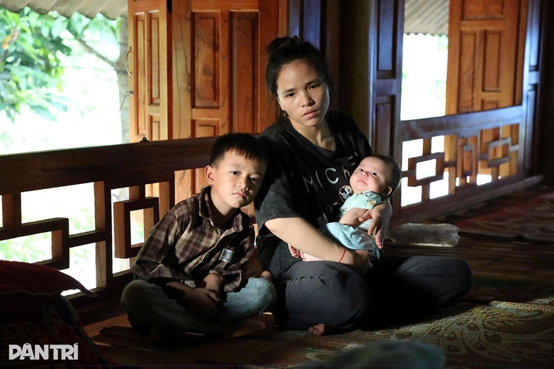 Cậu bé Quốc Bảo (ở thôn Cao Cầu 2, xã Bạch Xa, huyện Hàm Yên, tỉnh Tuyên Quang), ngồi bên mẹ cùng đứa em trai mới sinh chỉ 2 tháng tuổi, ánh mắt luôn chất chứa nỗi buồn man mác vì không còn hơi ấm của bố và tiếng cười đùa của em gái hàng ngày (Ảnh: Hữu Nghị)